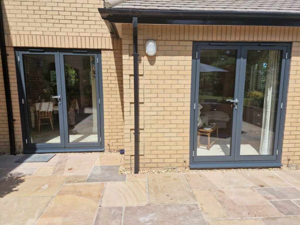 Grey aluminium French doors at the back of a new build house