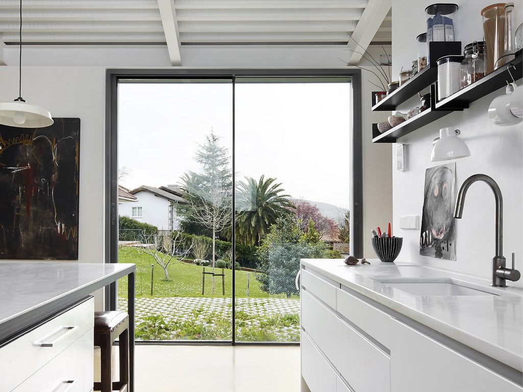 cvs 20 sliding door in a kitchen extension with lawn and rooftop views.